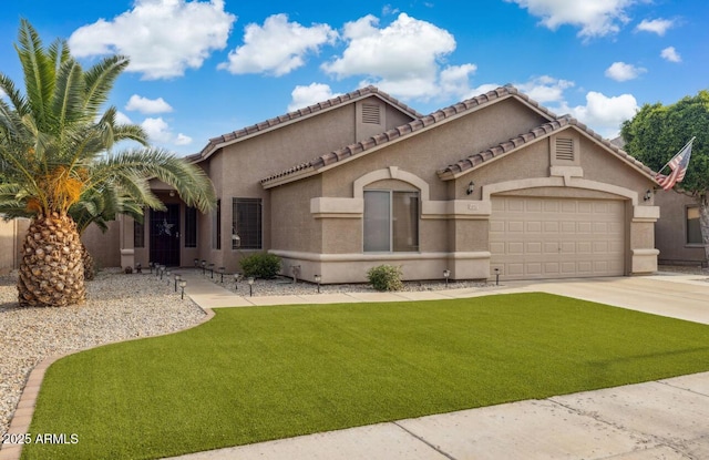 7457 W Crystal Rd, Glendale, AZ 85308 - mediterranean / spanish-style home featuring driveway, a tile roof, a garage, stucco siding, and a front lawn