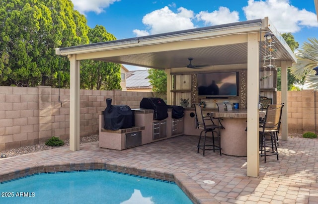 7457 W Crystal Rd, Glendale, AZ 85308 - view of pool featuring a ceiling fan, exterior kitchen, grilling area, outdoor wet bar, and fence private yard