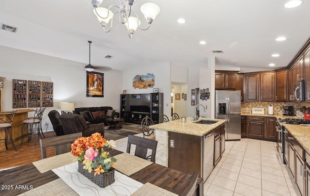 7457 W Crystal Rd, Glendale, AZ 85308 - kitchen with an island with sink, a sink, stainless steel appliances, visible vents, and backsplash