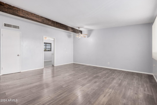 spare room with beam ceiling, ceiling fan, and light hardwood / wood-style floors