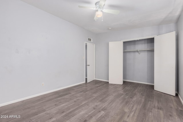 unfurnished bedroom featuring ceiling fan, wood-type flooring, and a closet