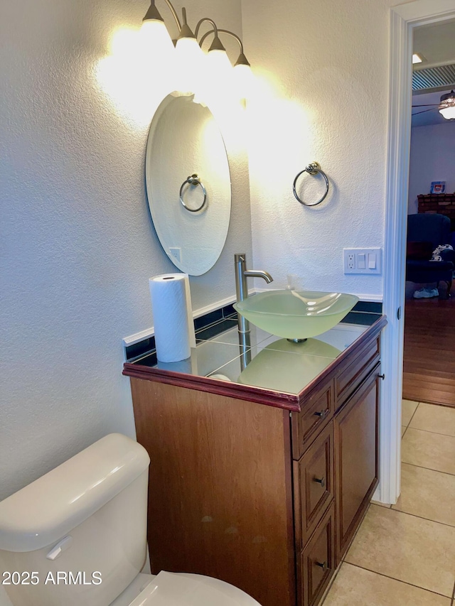 bathroom featuring tile patterned flooring, vanity, and toilet