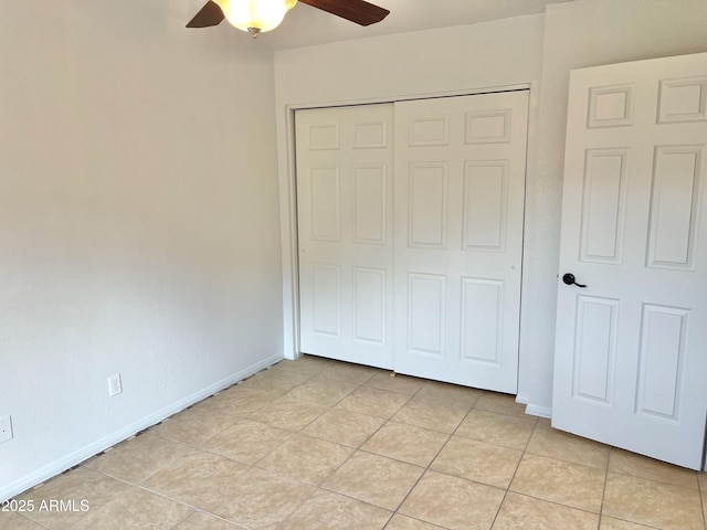 unfurnished bedroom with light tile patterned floors, ceiling fan, and a closet