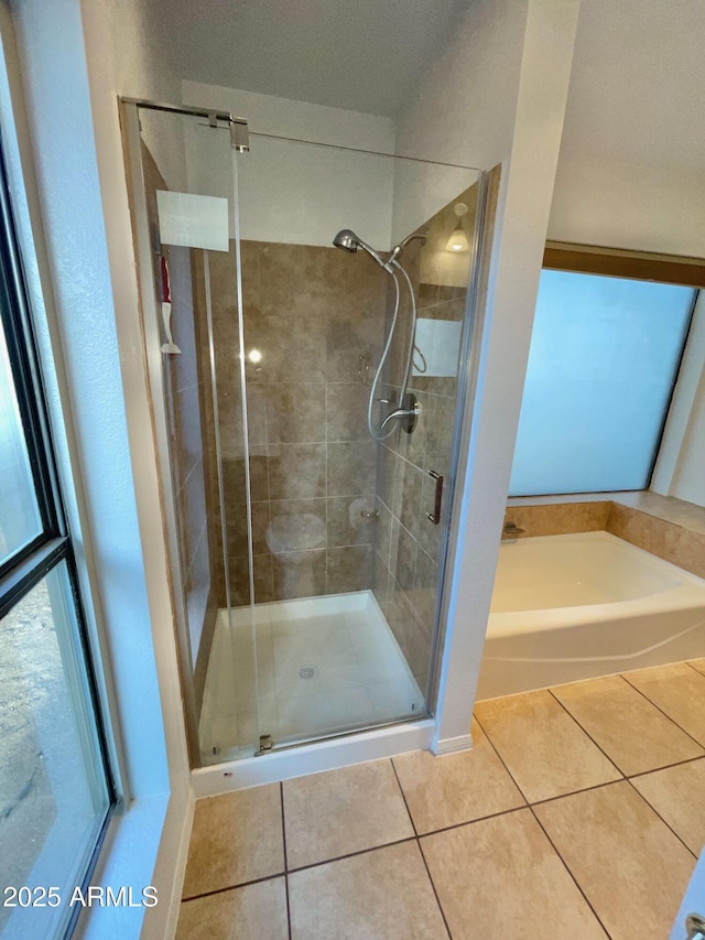 bathroom with tile patterned flooring and separate shower and tub