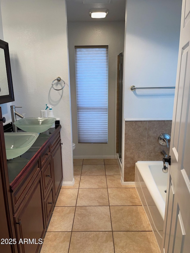 bathroom featuring vanity, a bathtub, tile patterned floors, and toilet