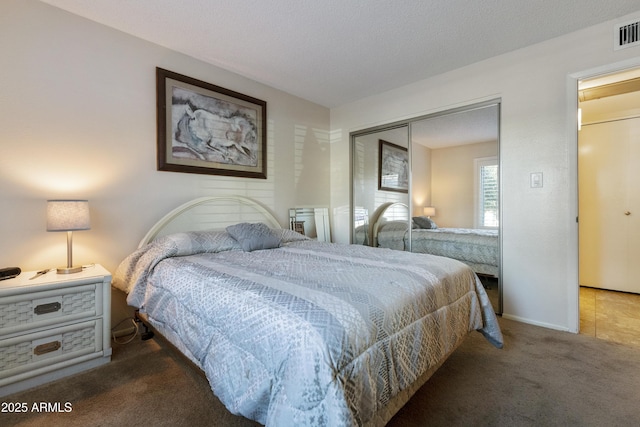 carpeted bedroom with a closet and a textured ceiling