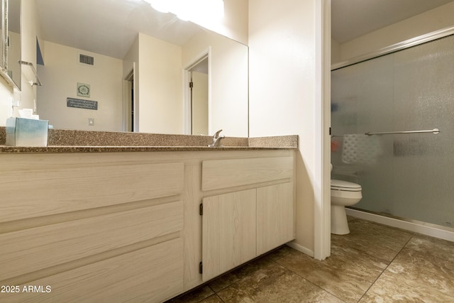 bathroom with vanity, a shower with shower door, and toilet