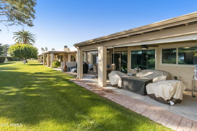 back of house featuring a patio, a yard, and ceiling fan