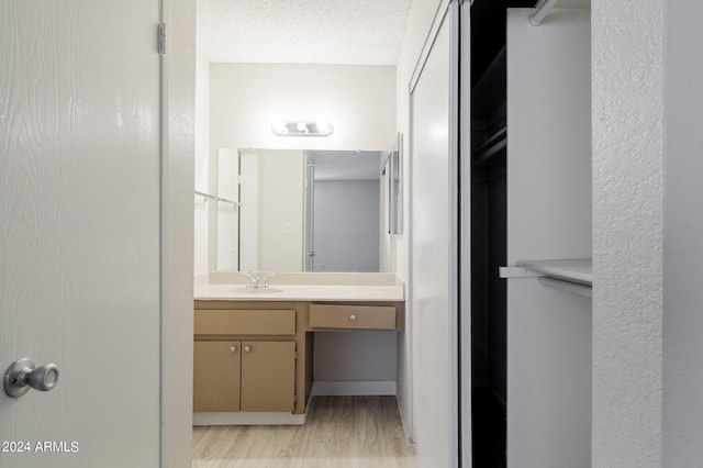 bathroom featuring a textured ceiling, vanity, and hardwood / wood-style flooring