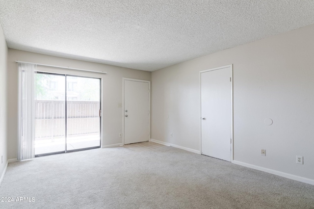 carpeted empty room featuring a textured ceiling