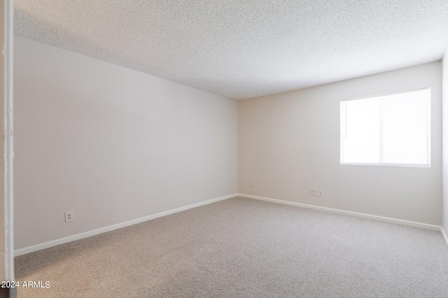 unfurnished room featuring carpet and a textured ceiling