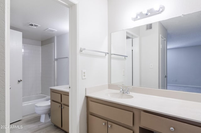 full bathroom featuring hardwood / wood-style floors, vanity, toilet, a textured ceiling, and shower / bathtub combination