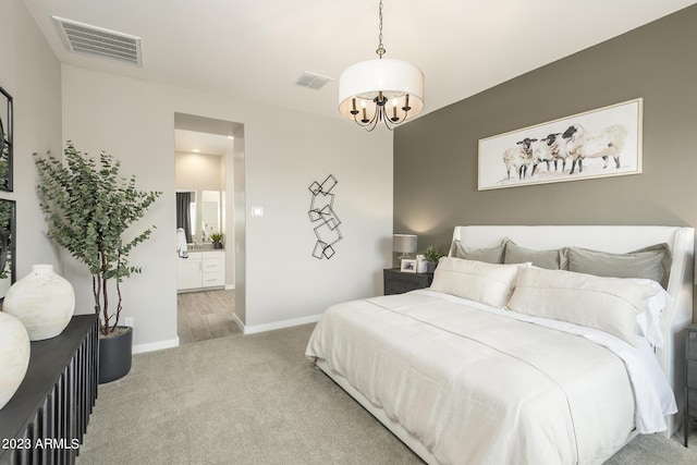 carpeted bedroom with ensuite bath and a chandelier