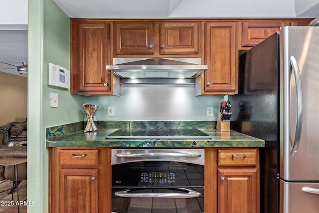 9012 S 47th Pl, Phoenix, AZ 85044 - kitchen with dark countertops, ventilation hood, brown cabinets, and black appliances