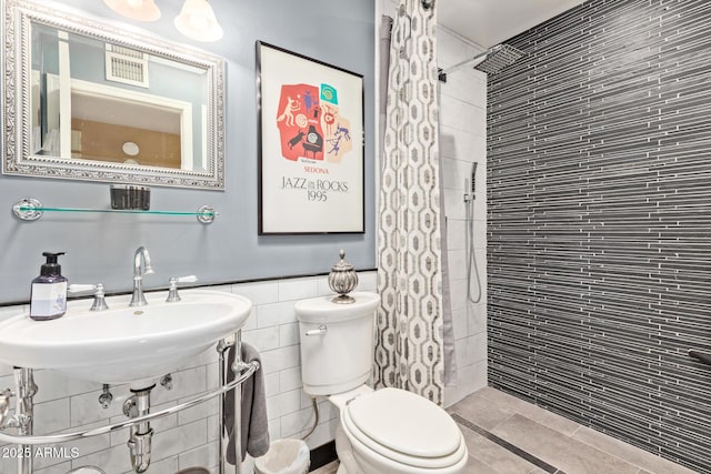 9012 S 47th Pl, Phoenix, AZ 85044 - bathroom featuring tile walls, toilet, tiled shower, and a sink