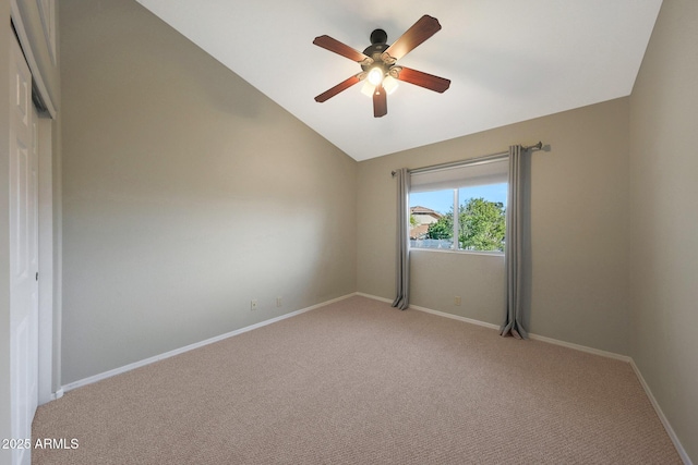 spare room featuring light carpet, lofted ceiling, and ceiling fan