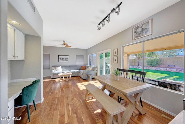 dining room featuring ceiling fan, light hardwood / wood-style floors, and track lighting