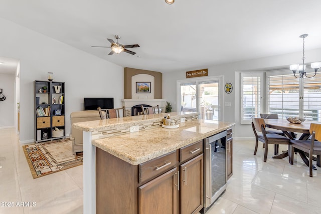 kitchen featuring pendant lighting, light tile patterned floors, a breakfast bar area, a kitchen island, and beverage cooler