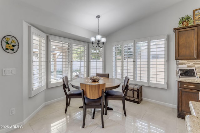 dining room with lofted ceiling, plenty of natural light, light tile patterned floors, and a notable chandelier