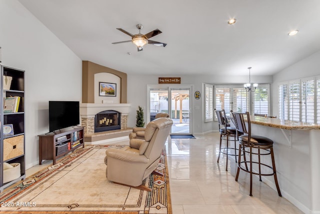 living room featuring ceiling fan with notable chandelier, vaulted ceiling, and a healthy amount of sunlight