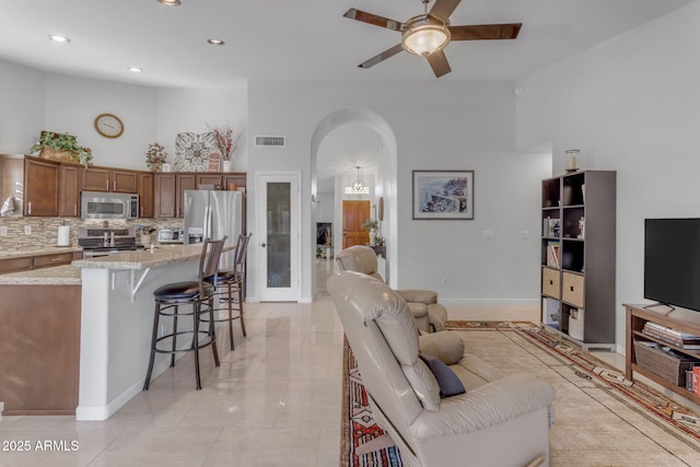 living room featuring a high ceiling and ceiling fan