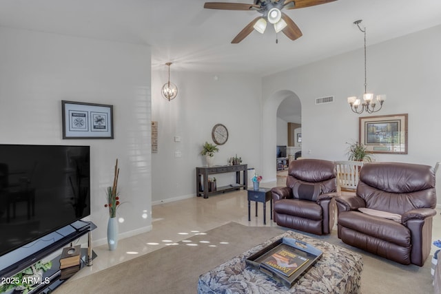 carpeted living room featuring ceiling fan with notable chandelier