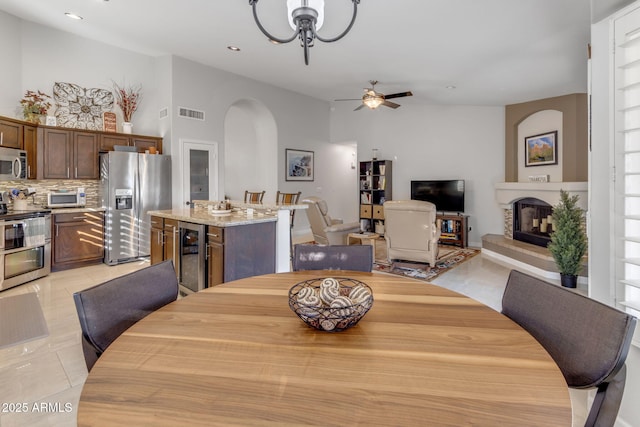 dining room with wine cooler, light tile patterned floors, and ceiling fan