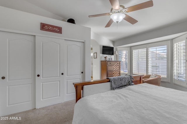 bedroom featuring ceiling fan, light carpet, and a closet