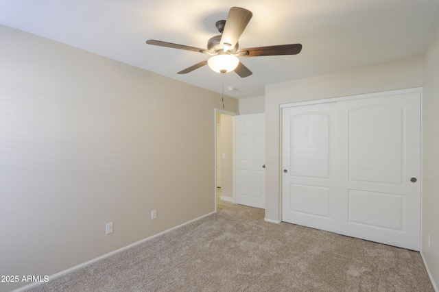 unfurnished bedroom with light carpet, a ceiling fan, baseboards, and a closet