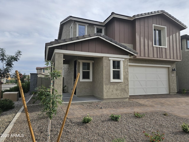 3390 S 180th Ln, Goodyear, AZ 85338 - view of front of house featuring a garage, decorative driveway, stucco siding, and a tiled roof