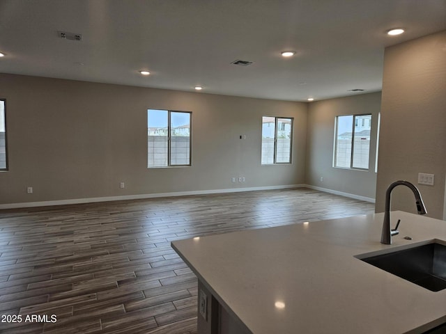 3390 S 180th Ln, Goodyear, AZ 85338 - kitchen featuring a sink, dark wood-style flooring, open floor plan, healthy amount of natural light, and recessed lighting