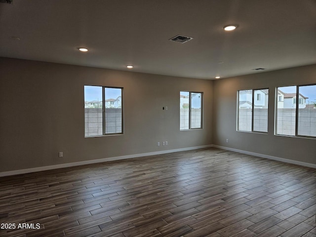 3390 S 180th Ln, Goodyear, AZ 85338 - empty room with dark wood-style floors, healthy amount of natural light, baseboards, and recessed lighting