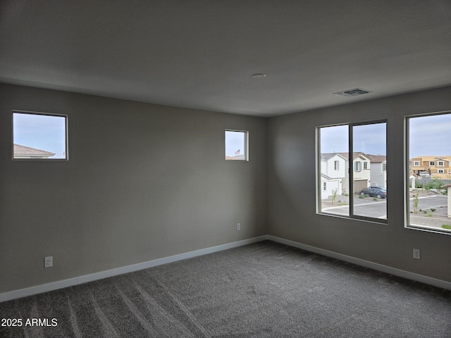 3390 S 180th Ln, Goodyear, AZ 85338 - spare room featuring dark colored carpet and baseboards