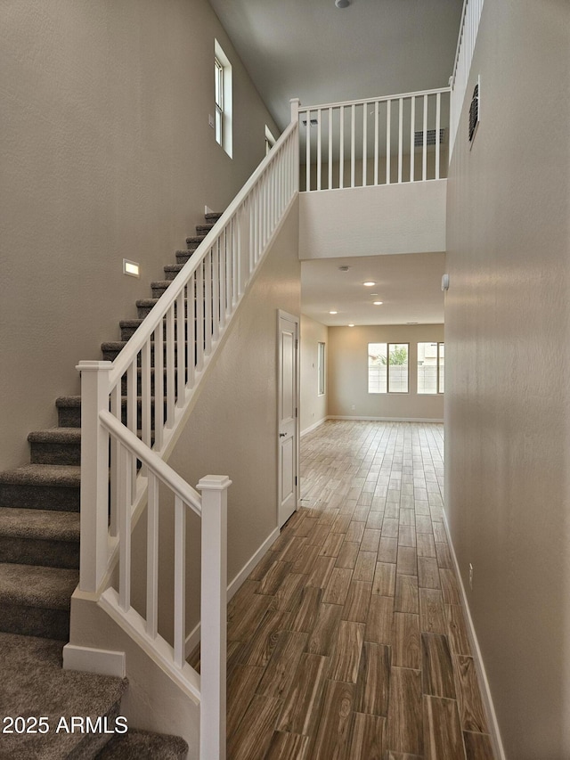 3390 S 180th Ln, Goodyear, AZ 85338 - stairs with wood finished floors, baseboards, and a high ceiling