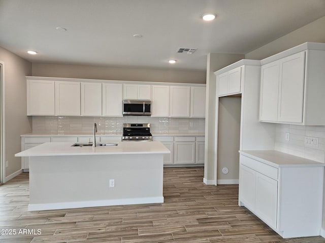 3390 S 180th Ln, Goodyear, AZ 85338 - kitchen with a sink, stainless steel appliances, decorative backsplash, white cabinetry, and recessed lighting