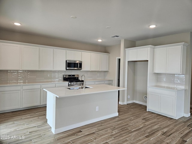 3390 S 180th Ln, Goodyear, AZ 85338 - kitchen featuring stainless steel appliances, decorative backsplash, light wood-type flooring, a sink, and recessed lighting