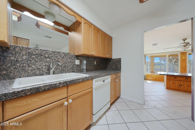 kitchen with light tile patterned floors, a sink, dishwasher, dark countertops, and backsplash