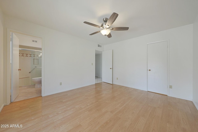 unfurnished bedroom with light wood-style flooring, visible vents, and ensuite bathroom