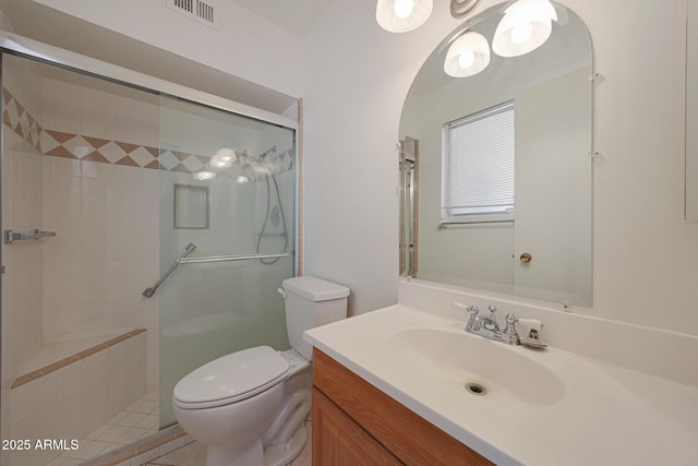 bathroom with visible vents, toilet, a stall shower, and vanity