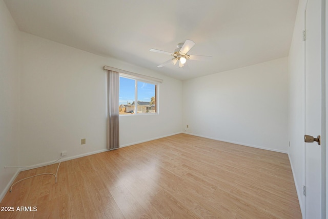 unfurnished room featuring baseboards, light wood-type flooring, and a ceiling fan