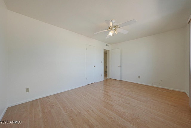 spare room featuring visible vents, baseboards, a ceiling fan, and light wood finished floors