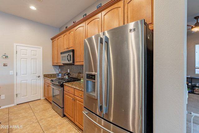 kitchen featuring light tile patterned floors, tasteful backsplash, recessed lighting, appliances with stainless steel finishes, and dark stone countertops