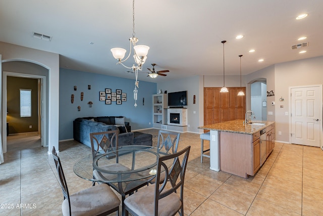 dining space featuring a warm lit fireplace, visible vents, a ceiling fan, and recessed lighting