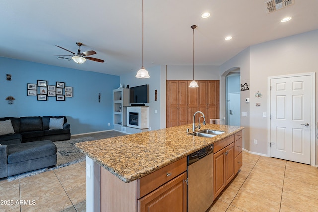 kitchen featuring light tile patterned flooring, a sink, visible vents, dishwasher, and a tiled fireplace