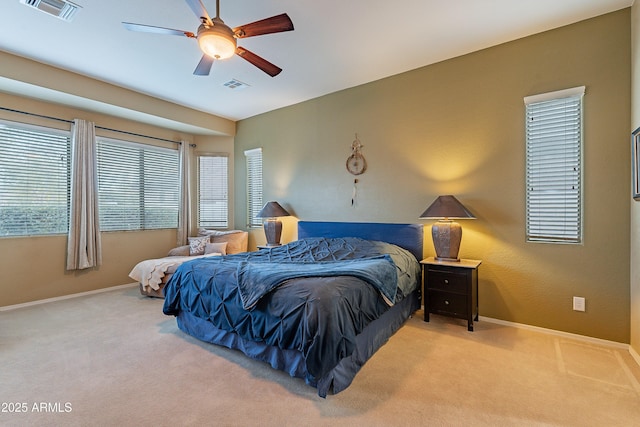 carpeted bedroom featuring a ceiling fan, visible vents, and baseboards