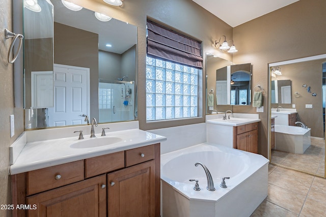 bathroom featuring a stall shower, a sink, a garden tub, tile patterned flooring, and two vanities