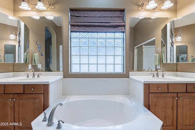 bathroom with two vanities, a sink, and a bath