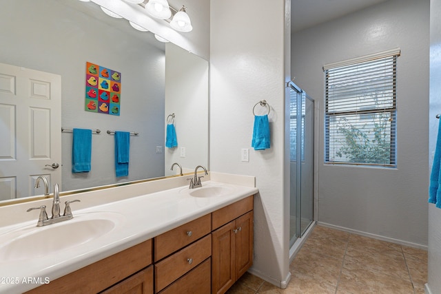 full bathroom featuring a stall shower, a sink, baseboards, and double vanity