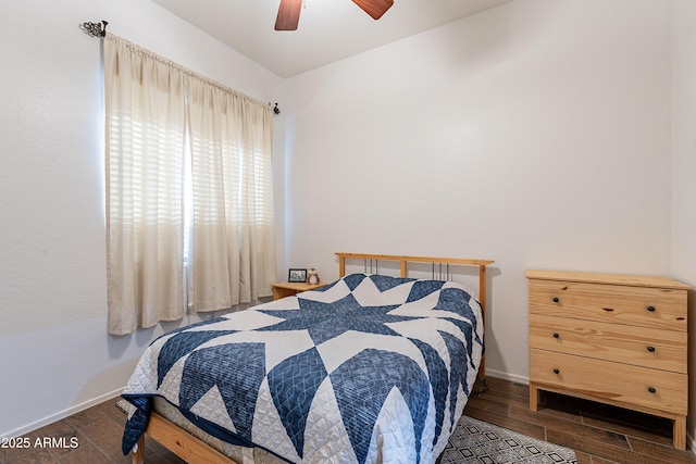 bedroom with ceiling fan, baseboards, and wood finished floors