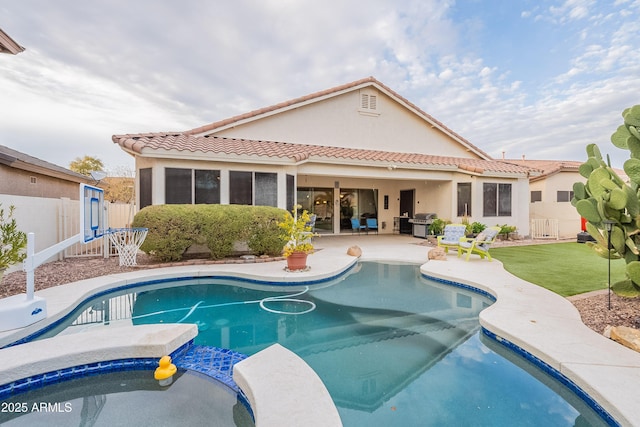 rear view of property with a fenced in pool, a tile roof, a patio area, and stucco siding